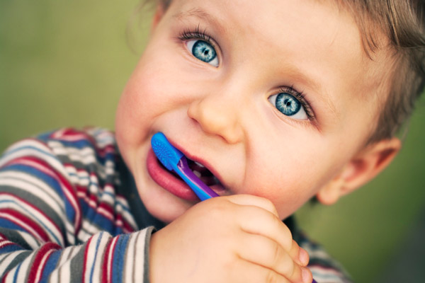 Portrait of toddler learning to brush his teeth