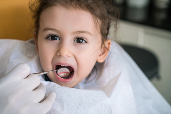 Dentist examining little girls teeth at Sierra Kids Dentistry in Reno, NV