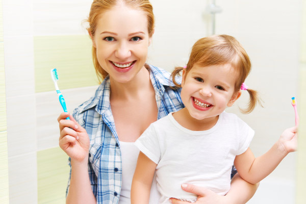 Mother and daughter smiling after brushing their teeth