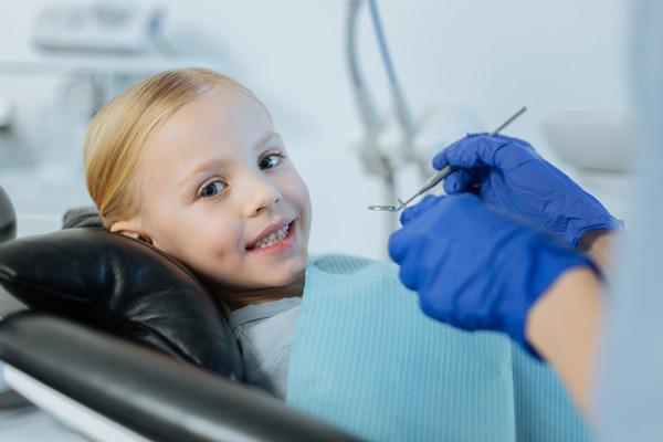 Blonde little girl smiling in dental chair