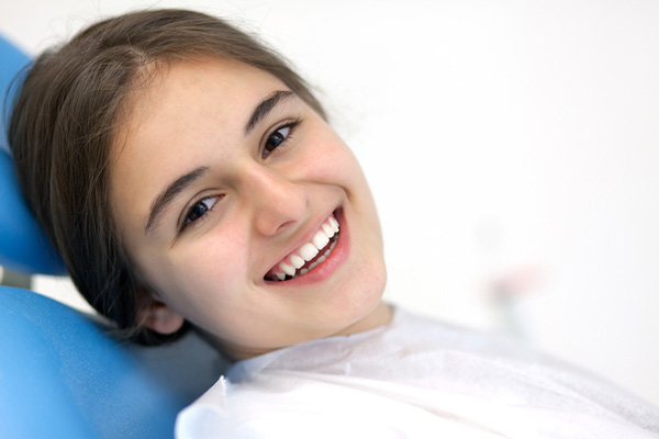 Smiling teenager sitting in dental chair at Sierra Kids Dentistry in Reno, NV