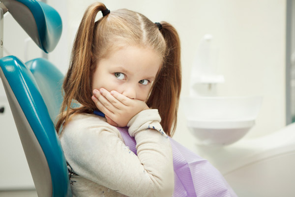 Little girl in dental chair with anxiety